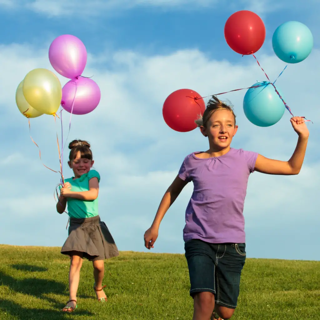 Kids holding helium balloons