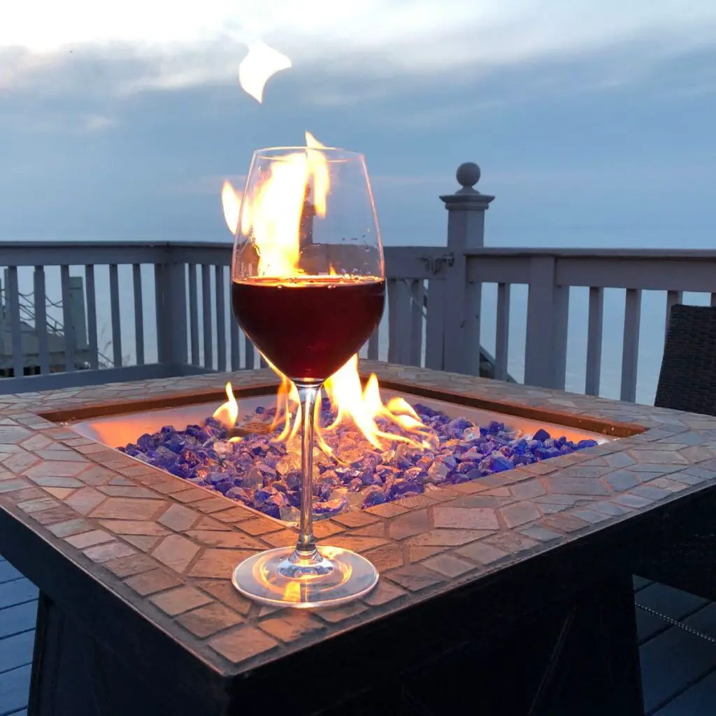 a glass of wine on a firepit