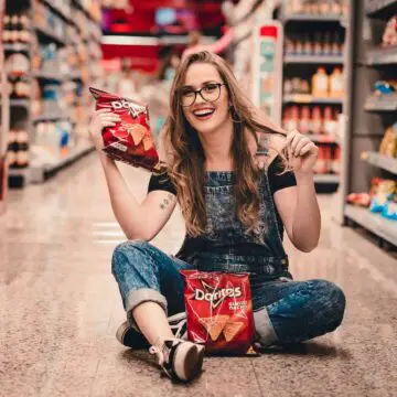 young lady holding a bag of Doritos